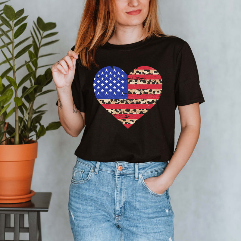 Woman wearing a black shirt with a red, white, and blue heart design.